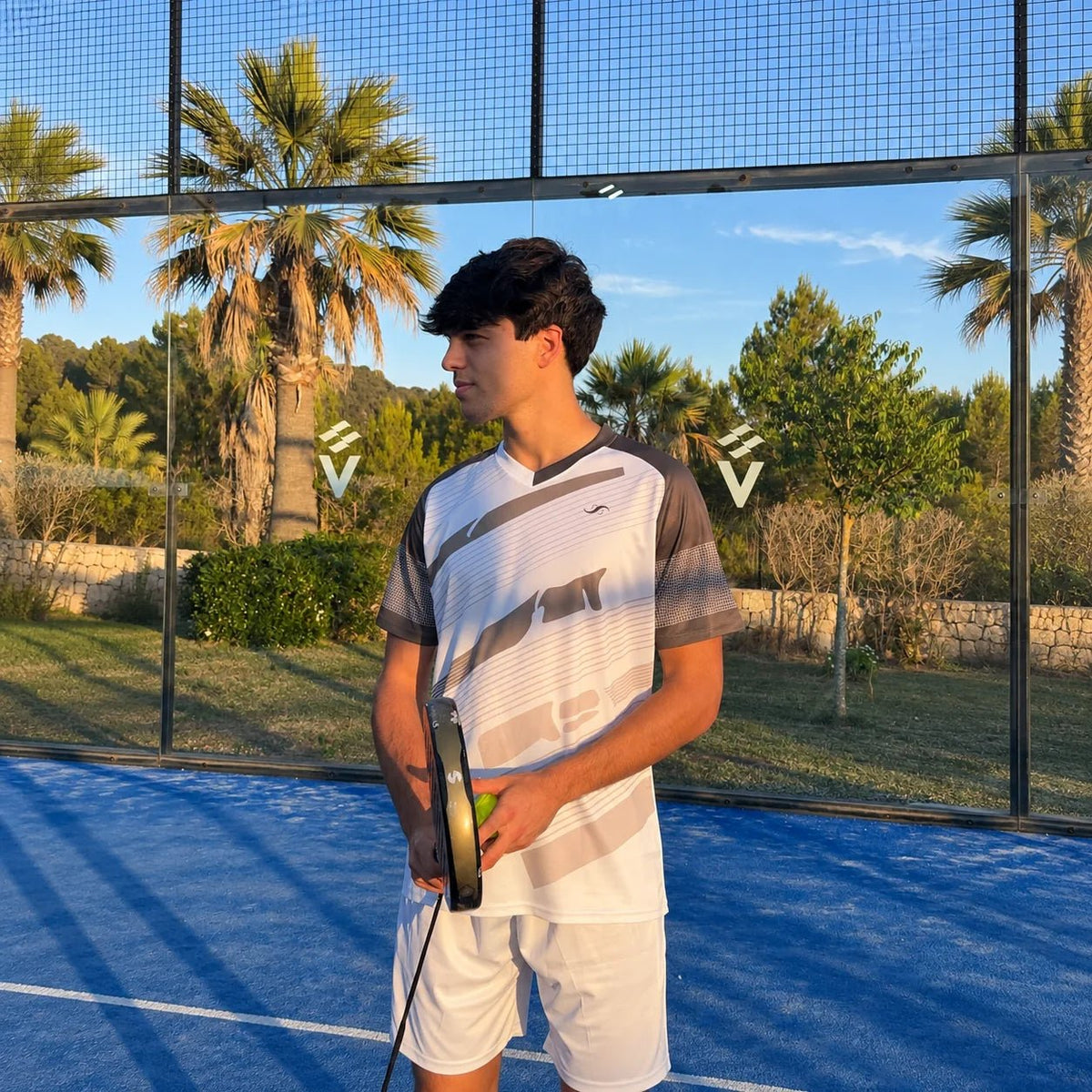 Detalle de camiseta de pádel blanca y gris con estampado degradado sobre el jugador